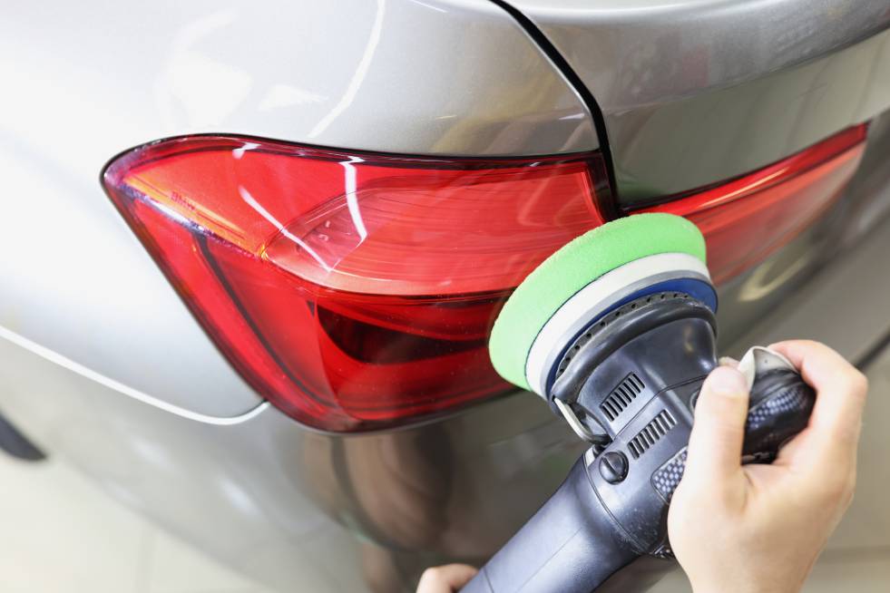 a person is polishing the paint of the car